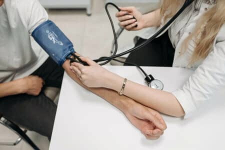 Healthcare worker measuring a patient's blood pressure using a sphygmomanometer