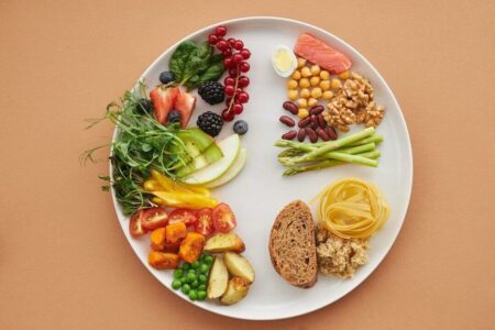 A colorful assortment of healthy food ingredients on a ceramic plate representing a balanced diet for heart health.
