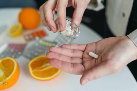A person taking a pill as part of their medication routine.
