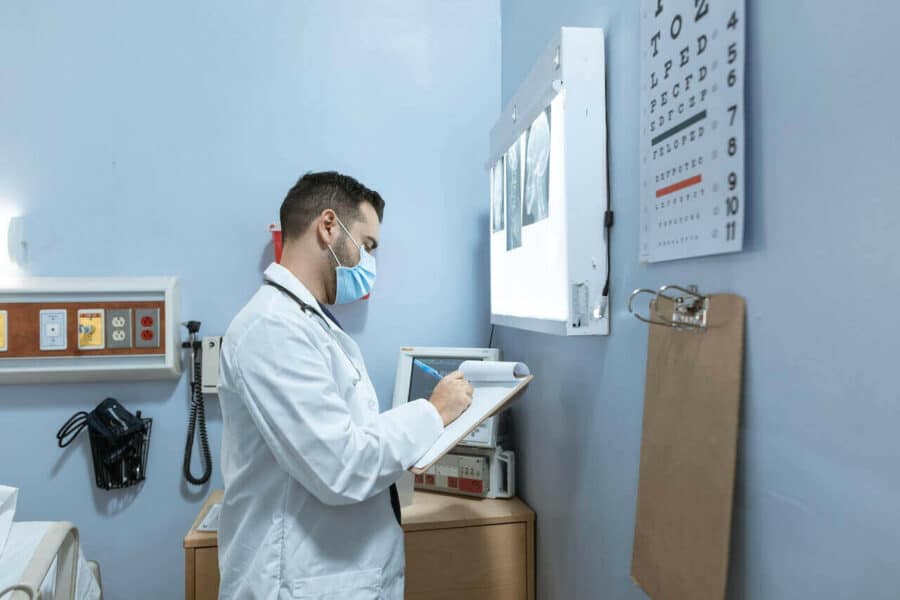 Doctor writing on a medical chart during a diagnosis