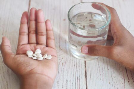 Close-up shot of tablets and a glass of water representing medication compatibility