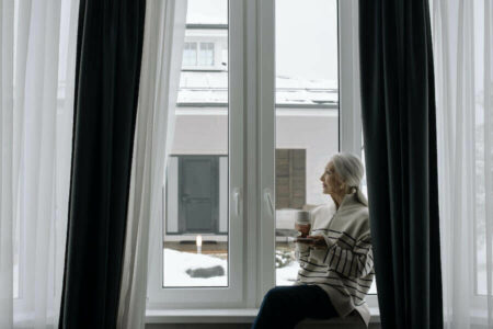 Elderly woman sitting beside a window